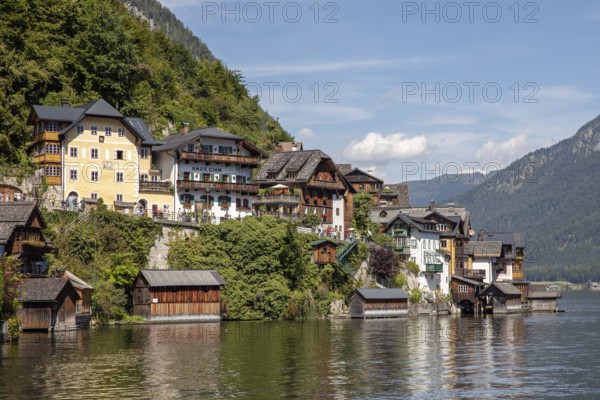 A, Hallstatt, picturesque buildings and traditional houses along the water, surrounded by mountains, Austria