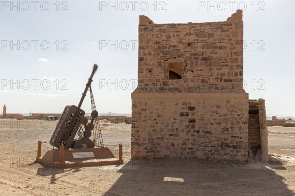 Stone buildings next to a metal circuit in the desert landscape