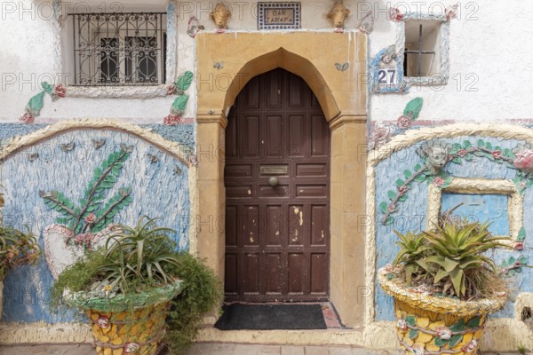 Traditionally decorated house entrance with plants and floral patterns