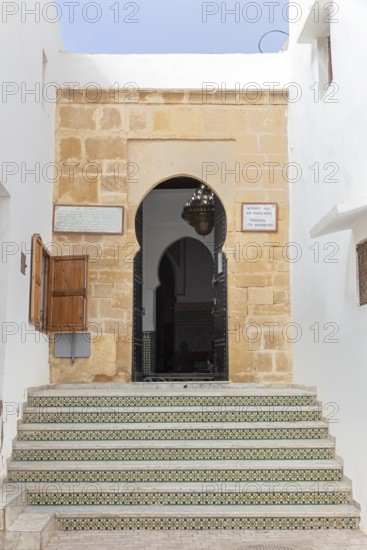 A stone staircase leads to an archway in a historic building