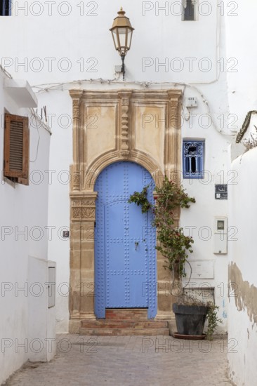Decoratively designed blue door with a lantern above
