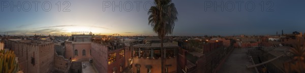 Beautiful city view at dusk after sunset with roofs and palm trees