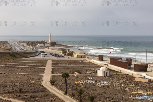 Coastal landscape with lighthouse and waves at sea, cloudy sky