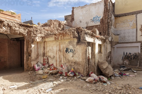 Dilapidated building with graffiti and trash in a deserted area, earthquake