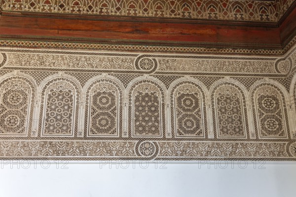 Complex arabesque patterns adorn a wall in a traditional style. Bahia Palace in Marrakech, Morocco