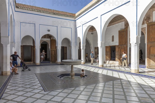 Moroccan courtyard with typical arches and fountains decorated with tiles at home in the sun, Bahia Palace in Marrakech, Morocco