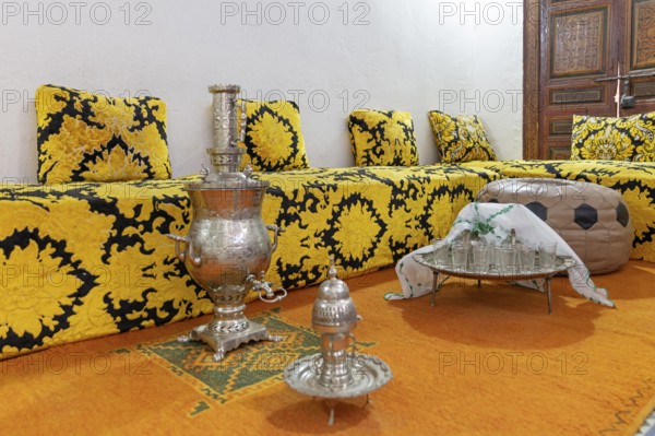 Inviting Moroccan sitting area with elaborate tea set on a decorative tray, Bahia Palace in Marrakech, Morocco