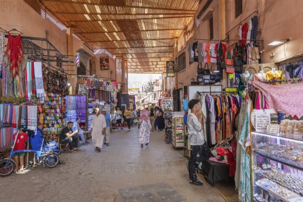 Traditional market hall with people strolling through colorful clothing stores