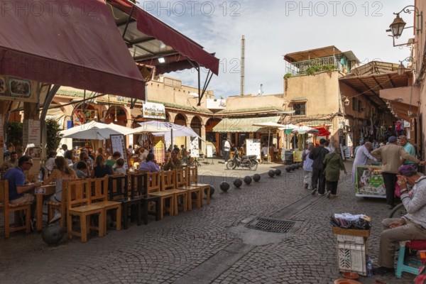 Friendly atmosphere in a street with open-air restaurants and people around tables