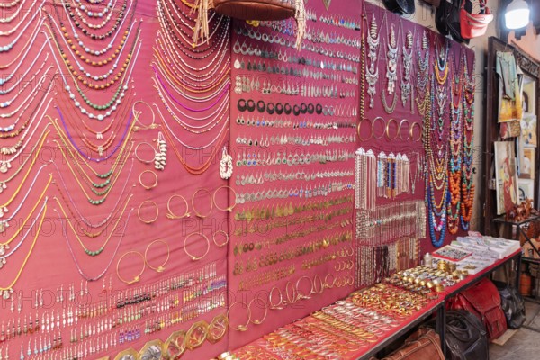 Market stand with colorful jewelry against a red background