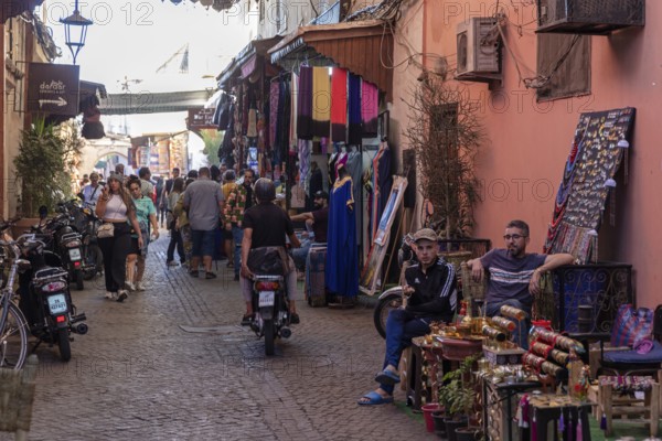 Lively market scene with shops and people on a narrow street