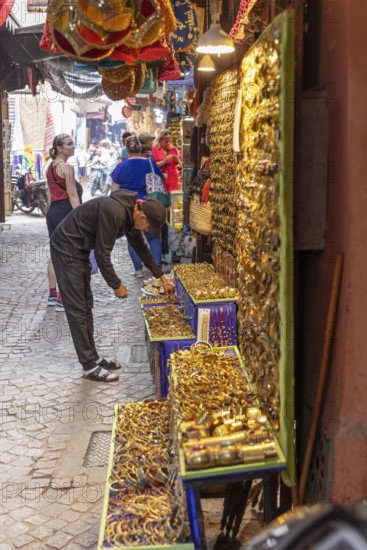Bustling market stall full of golden jewelry on a Moroccan souk street