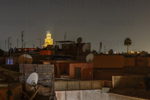 Night view in Marrakech with illuminated tower and satellite dishes