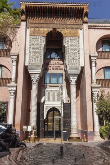 Decorated entrance façade of a building with columns and Moroccan ornaments