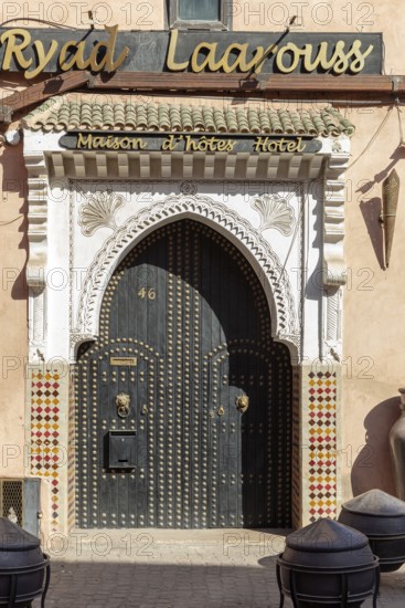 A traditional riad with a richly decorated entrance gate and Moroccan design elements in warm colors