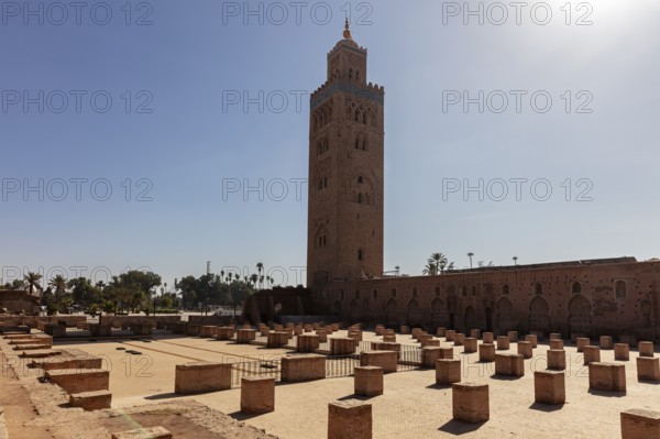 The Koutoubia Mosque in Marrakech with its tall minaret, surrounded by archaeological remains in bright sunshine