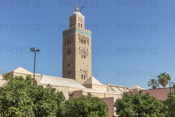 Side view of the Koutoubia Mosque with its impressive tower and palm trees