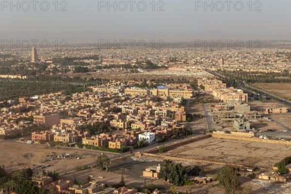 Aerial view of a city in the desert with characteristic orange buildings and architectural structures