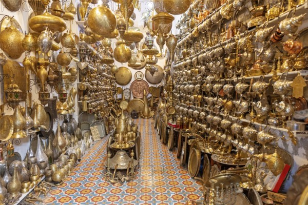 A dense collection of golden, artistically crafted Moroccan lamps