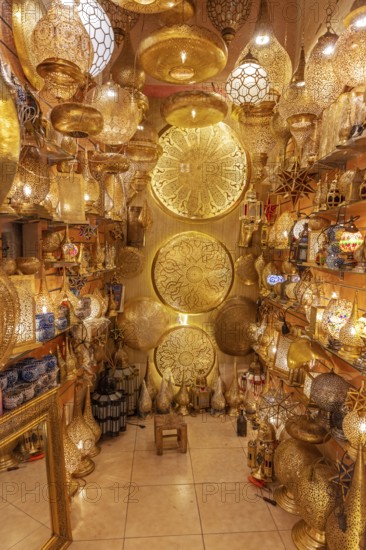 A room with numerous golden, artfully designed Moroccan lamps