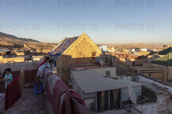 Rooftop with views of house-lined hills at dusk