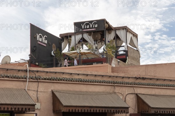Café on an urban roof terrace with curtains and a relaxing atmosphere under a blue sky