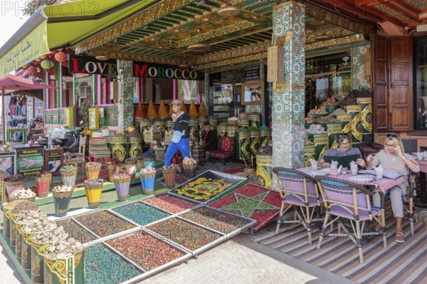 Market full of spices and decorations, people strolling or sitting relaxed