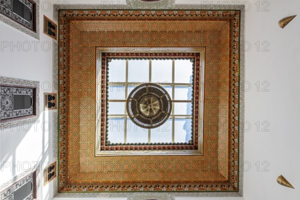 Ornately decorated ceiling with colorful mosaics and a large window