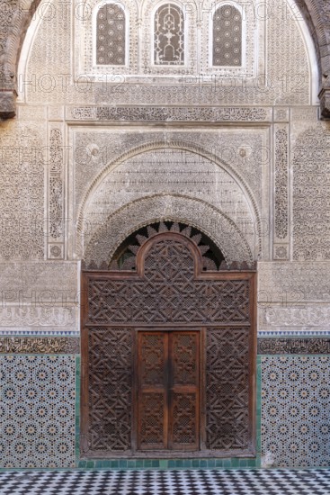 Richly decorated wooden door in a building with ornate mosaics