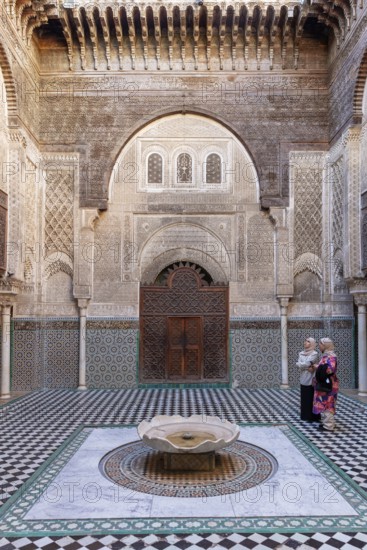 Traditional courtyard with ornate mosaics and a central water fountain