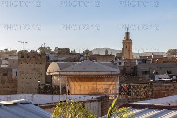 View over the rooftops of the city with a tower and a clear sky in the background