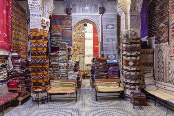 A colorful market stand full of traditional rugs and fabrics