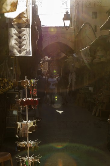 An atmospheric play of light and shadow in a narrow, sunny market alley