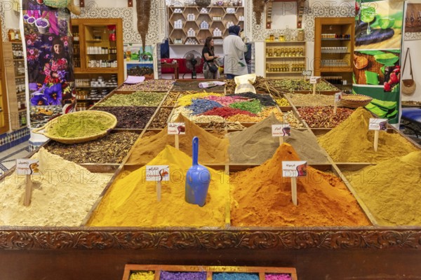 A market stand that presents a variety of colorful spices and aromatic products in various shades