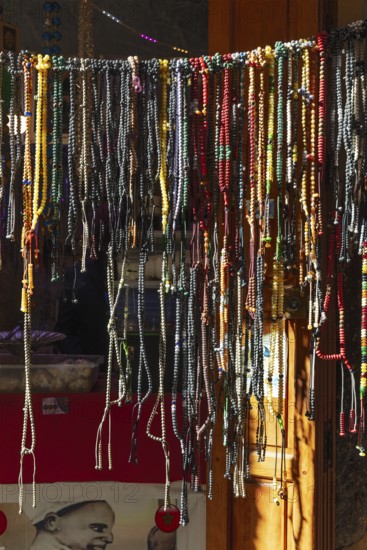 A variety of colorful chains hang on a shop door in an artisan shop