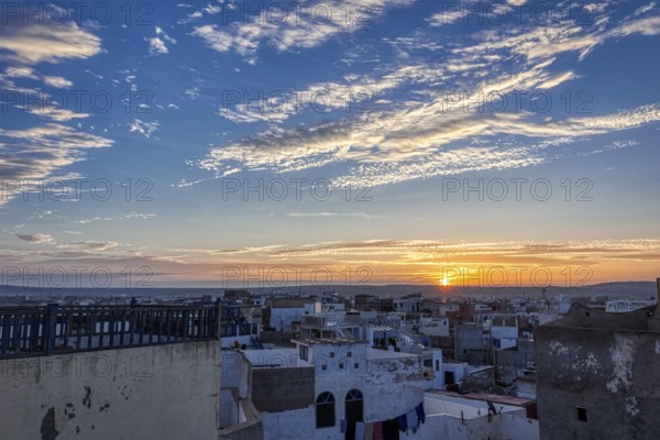 Peace and beauty at sunrise that appears over the rooftops of a city with picturesque skies