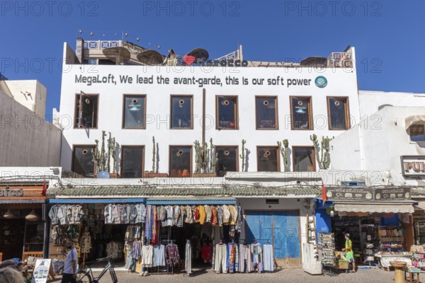 Modern building with eye-catching lettering over shops and blue sky
