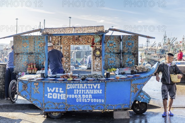 Decorative blue market stand at a lively harbor