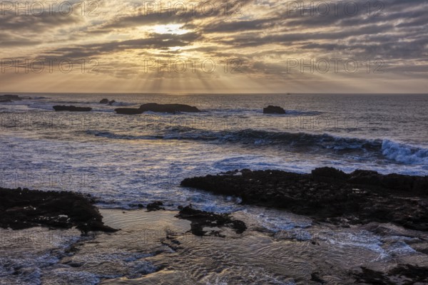 Dramatic cloud formations and sunbeams over the sea at sunset