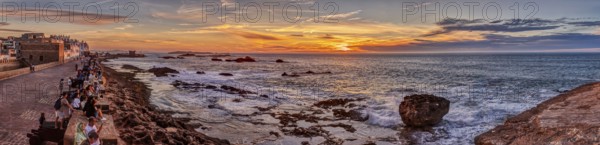 Spectacular sunset view of the sea with city and rocks
