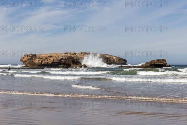 Rocky coast with breaking waves under clear sky