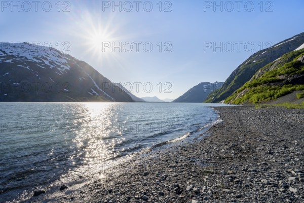 Landscape on glacial lake Portage Lake with sun star, Chugach National Forest, Alaska, USA