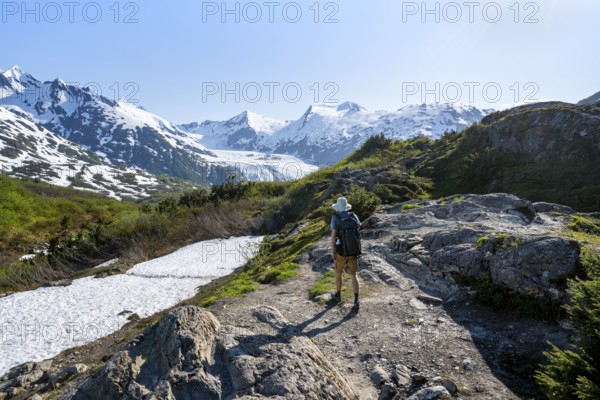 Hikers on the Portage Pass Trail, snow-covered mountains and Portage Glacier glaciers, near Whittier, Alaska, USA