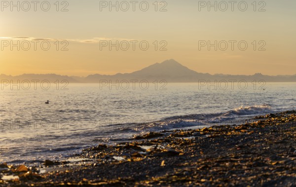 View of Cook Inlet on white mountain peaks of Mount Redoubt at sunset, midnight sun, Aleutian mountains, Anchor Point, Anchor River State Recreation Area, Alaska, USA