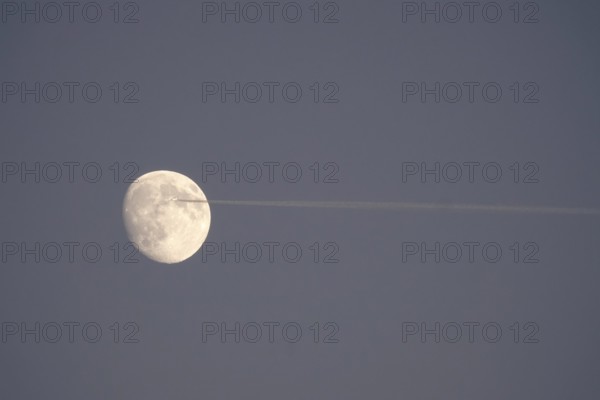 Airplane and moon, winter evening, Germany