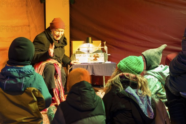 Storyteller with children at the Elbhangfest Christmas market in Dresden Loschwitz in the historic village center of Loschwitz during Advent, Dresden, Saxony, Germany