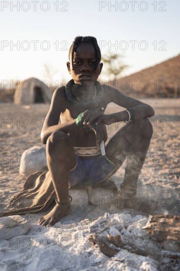 Himba child at the fire early in the morning, traditional Himba village, Kaokoveld, Kunene, Namibia