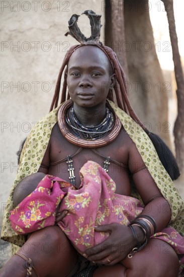 Baby in the arms of a Himba woman, traditional Himba village, Kaokoveld, Kunene, Namibia