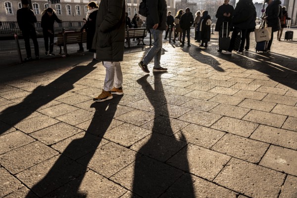 Passers-by on a sidewalk on Grunerstraße, near Alexander Platz, bus stop, in Berlin, shade, low sun, winter, Germany