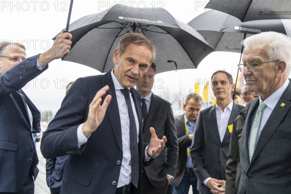 Annual event on the BW Automotive Industry Strategy Dialogue (SDA) in Stuttgart. Car managers standing in the rain with umbrellas: Oliver Blume, (CEO Porsche AG and Volkswagen AG) . Ola Källenius (Chief Executive Officer of Mercedes-Benz Group AG) . Gerd Walker (AUDI AG, Chief Logistics Officer) . On the right, Winfried Kretschmann, (Greens, Minister-President BW) . Automotive industry conference. Stuttgart, Baden-Württemberg, Germany